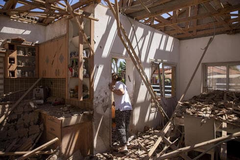 Una mujer inspecciona su casa dañada después de que fuera alcanzada por un cohete disparado desde la Franja de Gaza, en Sderot. 