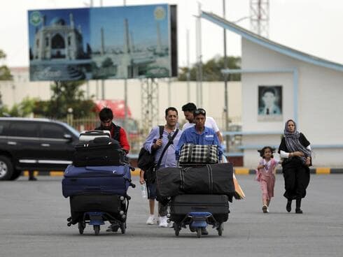 Ciudadanos afganos se dirigen al aeropuerto Hamid Karzai en Kabul para abandonar el país. (Rahmat Gul/AP) Ciudadanos afganos se dirigen el sábado al aeropuCiudadanos afganos se dirigen al aeropuerto Hamid Karzai en Kabul para abandonar el país.