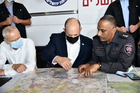 El ministro de Seguridad Interior, Omer Barlev, y el primer ministro Naftalí Bennett, informados por el comisionado de Bomberos y Rescate, Dedi Simchi. (Yoav Dudkevitch) El ministro de Seguridad Interior, Omer Barlev, y el primer ministro Naftalí Bennett, informados por el comisionado de Bomberos y Rescate, Dedi Simchi.