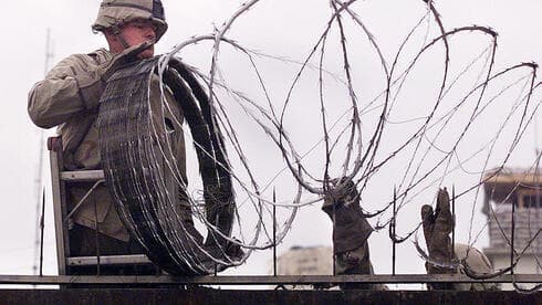 Un infante de marina estadounidense utiliza alambre de púas para proteger la embajada norteamericana en Kabul la semana pasada, mientras las fuerzas talibanes avanzaban hacia la ciudad. (AFP) Un infante de marina estadounidense utiliza alambre de púas para proteger la embajada norteamericana en Kabul la semana pasada, mientras las fuerzas talibanes avanzaban hacia la ciudad.