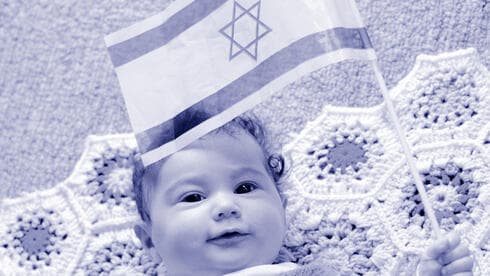 Un bebé sostiene una bandera de Israel. 