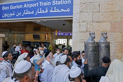 Peregrinos que regresan de Ucrania en el aeropuerto Ben Gurion, el 9 de septiembre de 2021. (AFP) Israelíes ortodoxos en Uman, Ucrania.