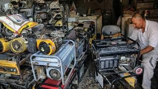 Un trabajador iraquí repara equipos electrógenos para producir energía eléctrica. 