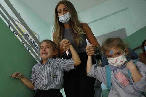 Una madre retira a sus hijas de un colegio durante los enfrentamientos.