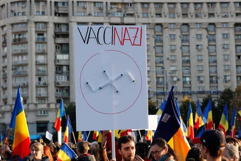 Hombre sujetando pancarta con jeringas en forma de esvástica durante una manifestación contra las nuevas medidas de salud en Rumania. (EPA ) Hombre sujetando pancarta con jeringas en forma de esvástica durante una manifestación contra las nuevas medidas de salud en Rumania.