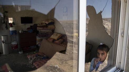 Una niña palestina observa a través de las ventanas rotas de su casa tras un ataque de radicales judíos. (AP) Una niña palestina observa a través de las ventanas rotas tras un ataque de radicales judíos.
