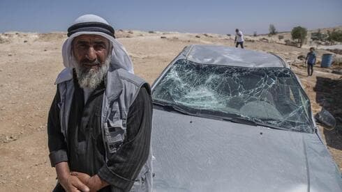 Un palestino junto a su auto atacado por radicales que residen en asentamientos de Cisjordania. (AP) Un palestino junto a su auto atacado por radicales que residen en asentamientos de Cisjordania.