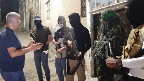 Hombres armados enmascarados de diferentes facciones palestinas hablan con el reportero de The Media Line, Mohammad Al-Kassim. 