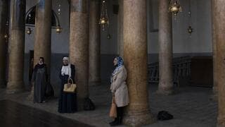 Mujeres posan para una foto junto a las columnas renovadas, durante una visita a la Iglesia de la Natividad en Belén, Cisjordania, el 16 de noviembre del 2021. 