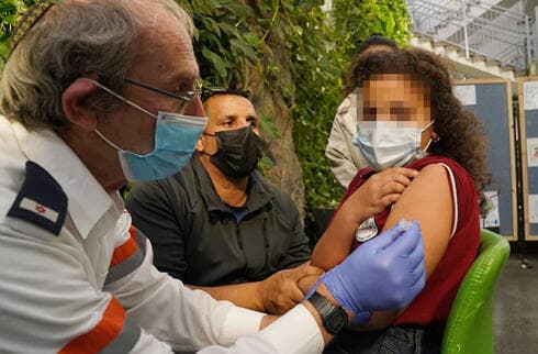 Una niña recibe su vacuna contra el coronavirus en una escuela en la ciudad árabe de Bu'eine Nujeidat. 