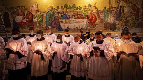 Sacerdotes con mascarillas rezan durante la misa del domingo de Pascua. 