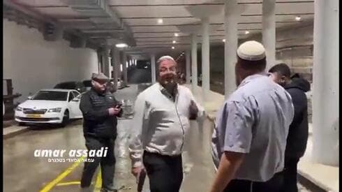 Ben Gvir discute con dos empleados de un estacionamiento mientras sostiene una pistola en su mano derecha. (Ynet) Pistola Ben Gvir