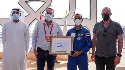 El astronauta de los Emiratos Árabes Unidos entrega la bandera de Israel. (Dubai Expo) El astronauta de los Emiratos Árabes Unidos entrega la bandera de Israel.