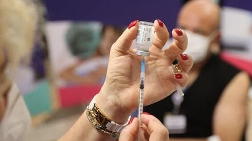 Una enfermera se prepara para administrar la cuarta dosis de la vacuna contra el coronavirus en el Centro Médico Sheba. (Motti Kimchi) Una enfermera se prepara para administrar la cuarta dosis de la vacuna contra el coronavirus en el Centro Médico Sheba.