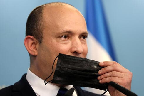El primer ministro Naftalí Bennett sostiene una mascarilla durante una conferencia de prensa sobre la situación del COVID-19 en Israel. (EPA) El primer ministro Naftalí Bennett sostiene una mascarilla durante una conferencia de prensa sobre la situación del COVID-19 en Israel.