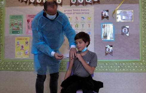 Un niño recibe una vacuna contra el COVID en una escuela. 
