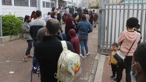 Fila de personas frente a un centro de testeo en Petah Tikva. 