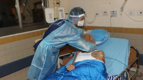 Personal de salud trabajando en un paciente infectado con COVID-19. 