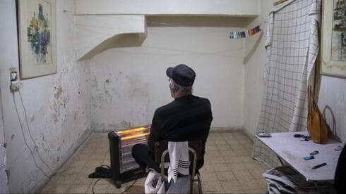 Un anciano empobrecido sentado en su destartalada casa de Jerusalem. 