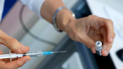 Una enfermera sostiene un vial de la vacuna COVID-19 y una jeringa en una clínica de vacunación en Tel Aviv.