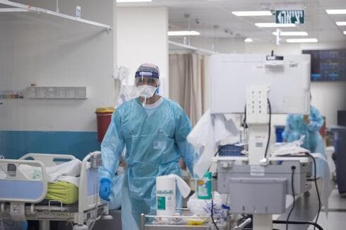 Trabajador de la salud caminan por una sala de coronavirus en el Centro Médico Shaare Zedek en Jerusalém. (Alex Kolomoisky) Trabajador de la salud caminan por una sala de coronavirus en el Centro Médico Shaare Zedek en Jerusalém.