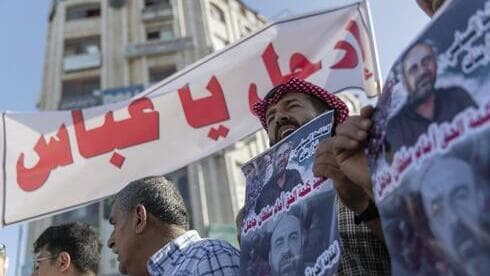 Manifestantes palestinos llevan carteles que dicen "Vete Abbas". 