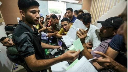 Hombres palestinos se reúnen para solicitar permisos de trabajo en Israel, en el campo de refugiados de Jabalia, en el norte de la Franja de Gaza.