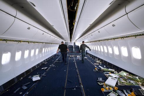 Trabajadores retiran del avión los asientos de los pasajeros. 
