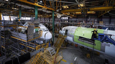 Ingenieros trabajan en la instalación de la nueva puerta que tendrá el avión de carga. 