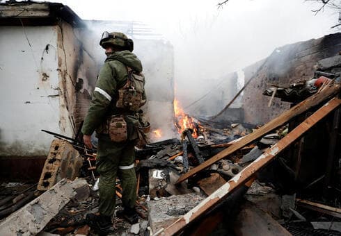 Un combatiente de la milicia prorrusa entre los escombros humeantes de una casa residencial destruida en los combates en la región separatista de Donetsk. 