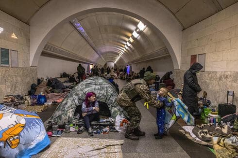 Un soldado ucraniano abraza a su hijo mientras miles de civiles se refugian de los bombardeos rusos en una estación de metro, en Kiev. 