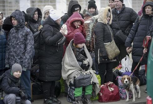 Personas que salieron de Ucrania esperan un autobús para llevarlos a la estación de tren en Przemysl, en el cruce fronterizo en Medyka, Polonia. (AP) Personas que salieron de Ucrania esperan un autobús para llevarlos a la estación de tren en Przemysl, en el cruce fronterizo en Medyka, Polonia.