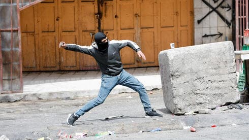 Un militante palestino lanza una piedra durante unos disturbios en la ciudad de Hebrón. (Reuters) Un militante palestino lanza una piedra durante unos disturbios en la ciudad de Hebrón.