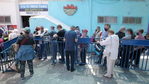 Personas que esperan en fila en Lod para recibir canastas de ayuda antes de la Pascua. (Shaul Golan) Personas que esperan en fila en Lod para recibir canastas de ayuda antes de la Pascua.