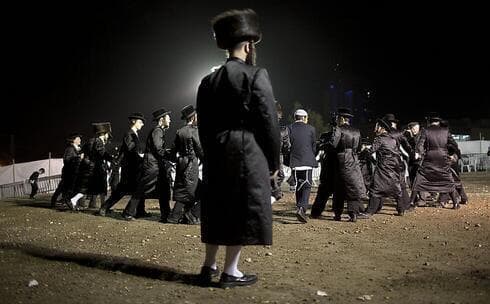 Hombres ultraortodoxos participan de un baile. 