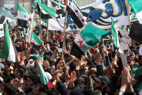 Manifestantes ondean banderas de la oposición siria durante una manifestación en la ciudad siria de Idlib, controlada por los rebeldes. (AFP) Manifestantes ondean banderas de la oposición siria durante una manifestación en la ciudad siria de Idlib, controlada por los rebeldes.