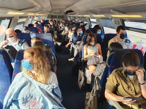 Pasajeros con mascarillas a bordo de un tren en Haifa. 