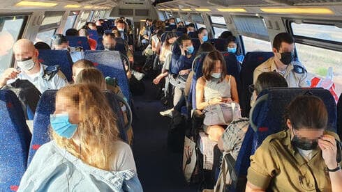 Pasajeros con mascarillas a bordo de un tren en Haifa. 