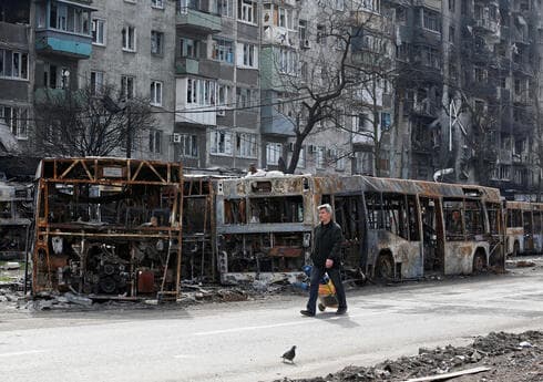 Un civil camina junto a autobuses carbonizados en medio del asedio ruso a Mariupol. (AFP) Un civil camina junto a autobuses carbonizados en medio del asedio ruso a Mariupol.