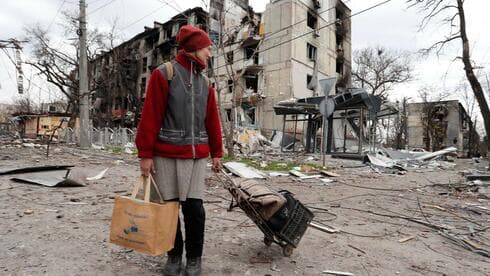 Una mujer camina entre los escombros que quedaron de Mariupol, asediada por bombardeos rusos. (AP) Una mujer camina entre los escombros que quedaron de Mariupol, asediada por bombardeos rusos.