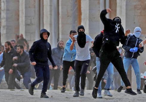 Manifestantes palestinos lanzando piedras contra las fuerzas israelíes en el recinto de la mezquita de al-Aqsa. (AFP) Manifestantes palestinos lanzando piedras contra las fuerzas israelíes en el recinto de la mezquita de al-Aqsa.