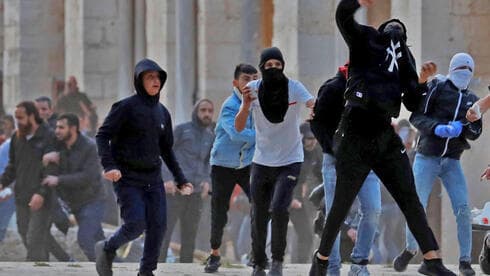 Palestinos arrojan piedras a la policía en el complejo de la mezquita de Al Aqsa a principios de este mes. 