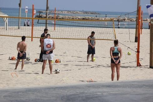 Jóvenes que practican deporte en una playa israelí rinden homenaje a las víctimas de la Shoá durante el sonido de la sirena. (Moti Kimchi) Yom HaShoá