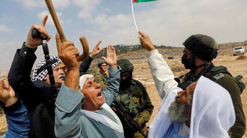 Manifestantes palestinos gesticulan junto a las fuerzas israelíes durante una protesta contra los asentamientos israelíes en Masafer Yatta, en Cisjordania, el 2 de octubre de 2021.