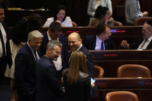 El canciller Lapid y el primer ministro Bennett sonríen tras el triunfo en la votación. (Amit Shavi) Lapid Bennett Knesset
