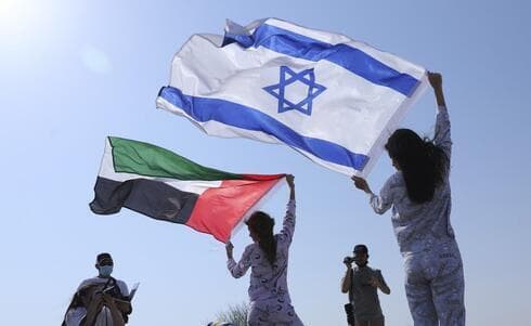 La modelo israelí May Tager, a la derecha, sostiene la bandera israelí junto a su compañera Anastasia Bandarenka, una modelo de Dubai originaria de Rusia, en una sesión fotográfica. (AP) La modelo israelí May Tager, a la derecha, sostiene la bandera israelí junto a su compañera Anastasia Bandarenka, una modelo de Dubai originaria de Rusia, en una sesión fotográfica.
