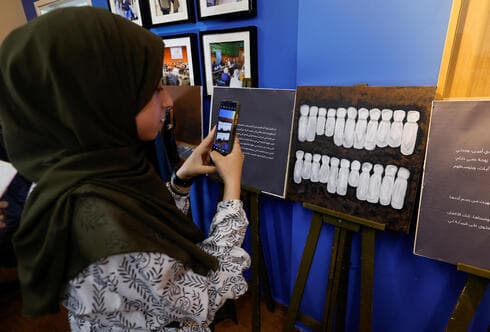 Niña palestina toma una foto durante la exposición de al-Qolaq. 