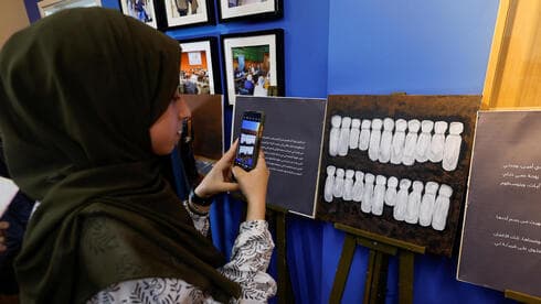 Niña palestina toma una foto durante la exposición de al-Qolaq. 