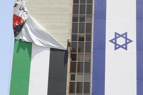 Retiro de la bandera palestina de un rascacielos en Ramat Gan la semana pasada. (Shaul Golan) Retiro de la bandera palestina de un rascacielos en Ramat Gan la semana pasada.
