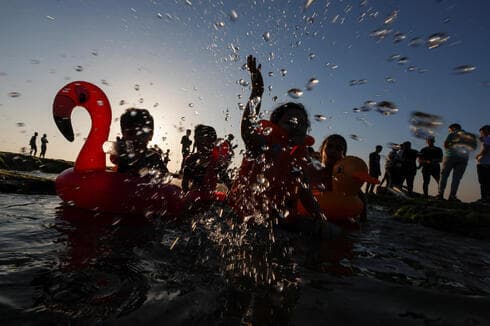 Niños juegan en el mar en la Franja de Gaza. 